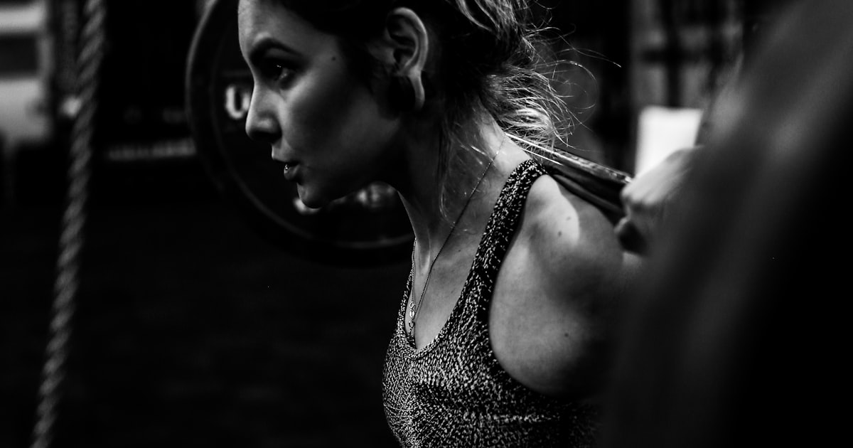 Woman performing a strength training exercise with dumbbells