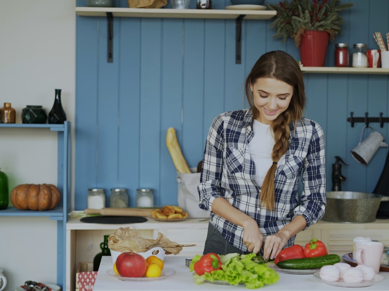 Woman chopping fresh vegetables in a bright kitchen