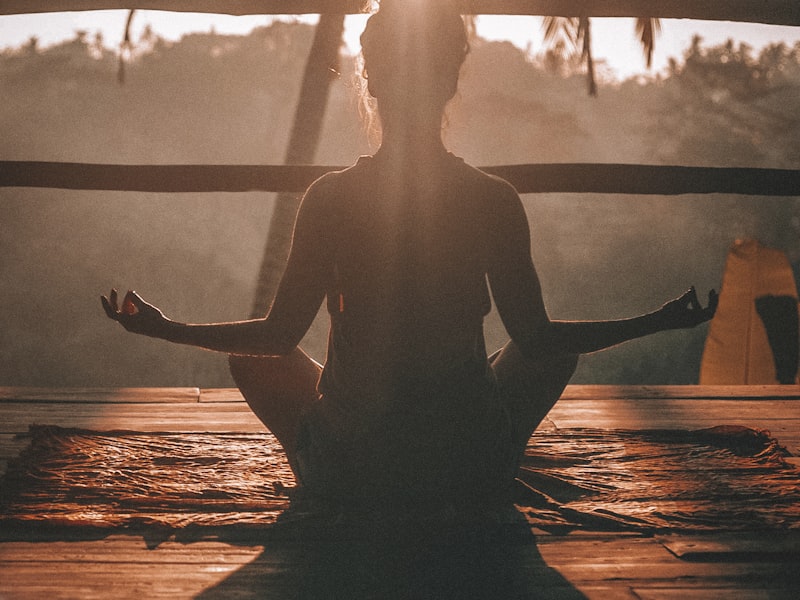 Woman meditating at sunset in a peaceful outdoor setting